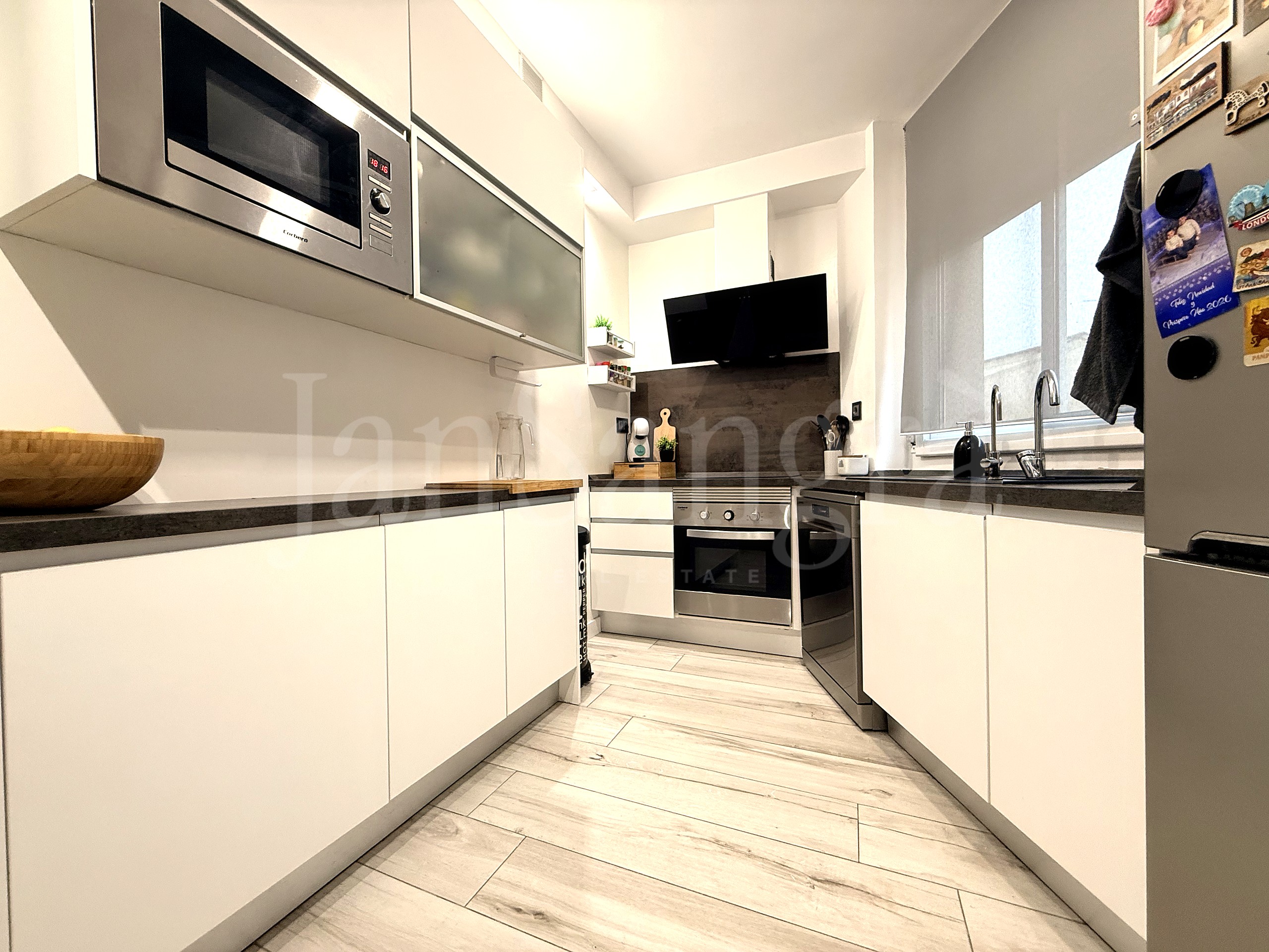 Cocina reformada con horno y microondas en columna